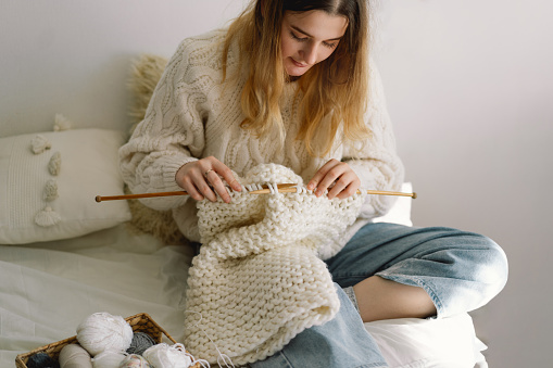Teengirl knitting at home. Handmade and Hobby. New small business employment opportunity concept. Needlework for mental health. Knitted background