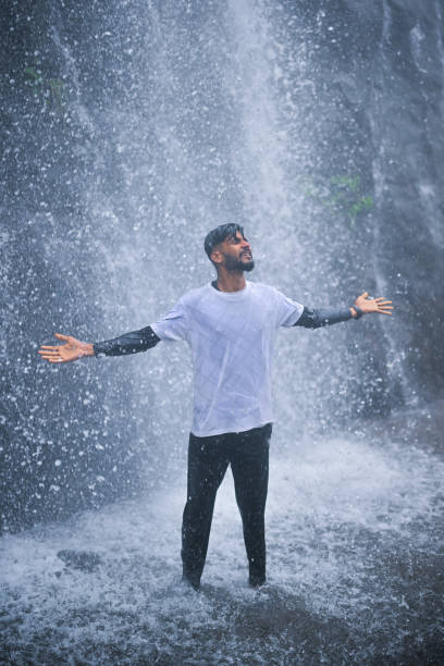istock A young man enjoying under a serene waterfall 1589790705