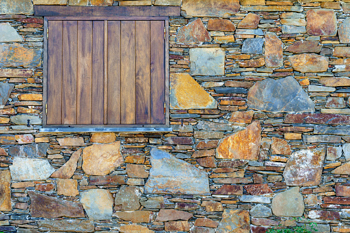 ancient old weathered and textured outdoor shuttered window features of a schist village homes