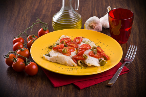 Fish with cherry tomatoes and olive.