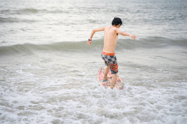istock Young people surfing on beach surfboards 1589862459