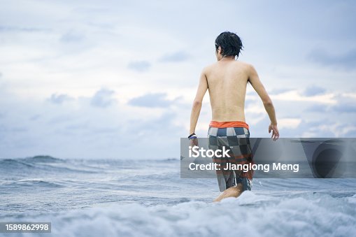istock Young people surfing on beach surfboards 1589862998