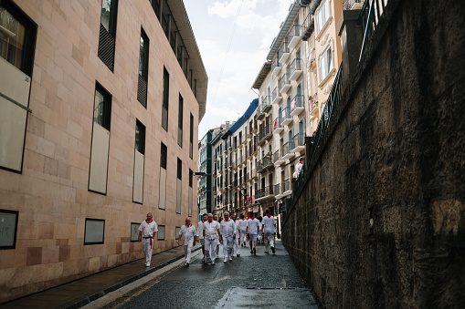 Pamplona, Spain - 7 July 2023: Cuesta de Santo Domingo in Pamplona, Navarra, Spain, with people wearing white and red clothes. This street is part of the San Fermin running of the bulls route.