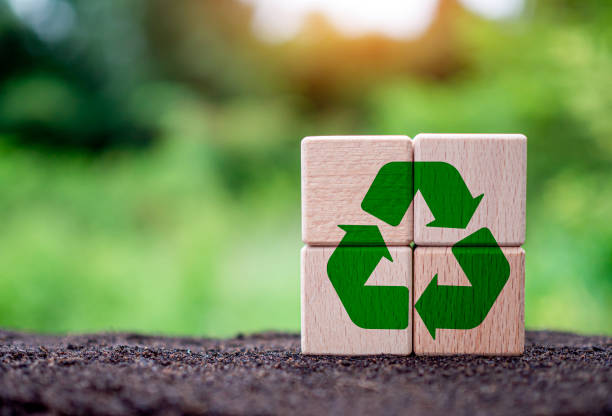 istock Concepts of waste reduction, pollution, reuse, efficient use of resources. Environmental protection sign by recycling on circular wooden blocks on nature background. 1589865717