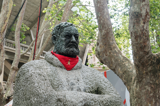 Pamplona, Spain - 7 July 2023: An Ernest Hemingway statue with a San Fermin celebration red neckerchief
