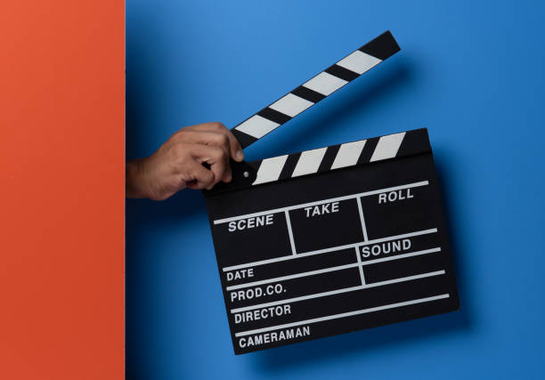 istock Hand is holding clapper board or clapperboard or movie slate on blue background. 1589879940