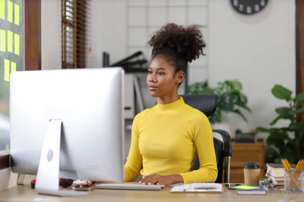 istock Attractive african american woman working with computer and financial documents in office. 1589888876