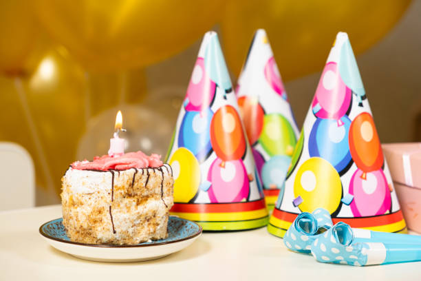istock A small piece of cake with a burning birthday candle. 1589891399