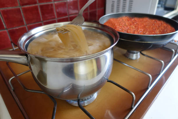 istock Spaghetti and bolognese sauce being cooked on a gas hob 1589894061