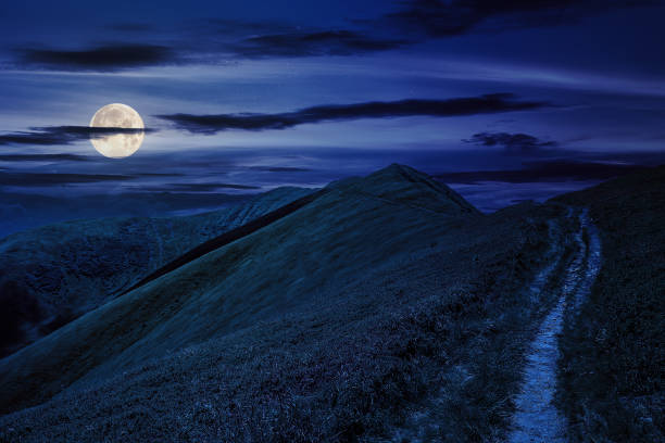 istock mountain landscape. path through hill side to the mountain top at night 1589897580