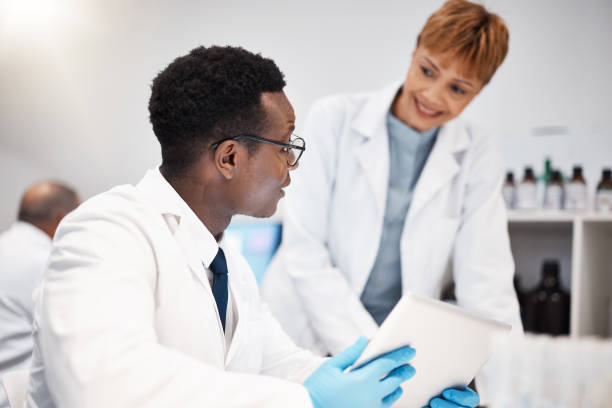 istock Science team, research and people with tablet in laboratory for experiment, study and medical results. Healthcare, pharmaceutical and scientists talking with digital tech for vaccine data analysis 1589911676