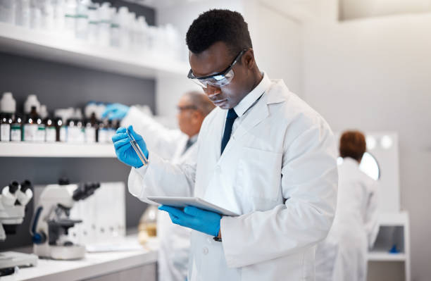 istock Science, research and black man in laboratory with tablet for medical analysis and digital innovation in medicine. Pharmaceutical analytics, web and scientist in South Africa checking results online. 1589911699