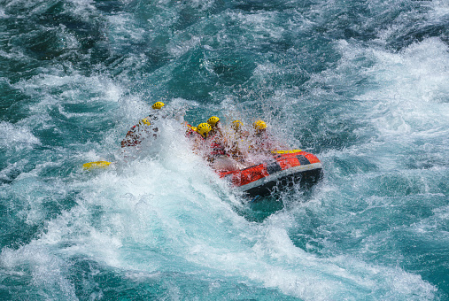 Group of people as they ride the rapids while white water rafting in the waves of a river. Koprulu Canyon Antalya, Turkey