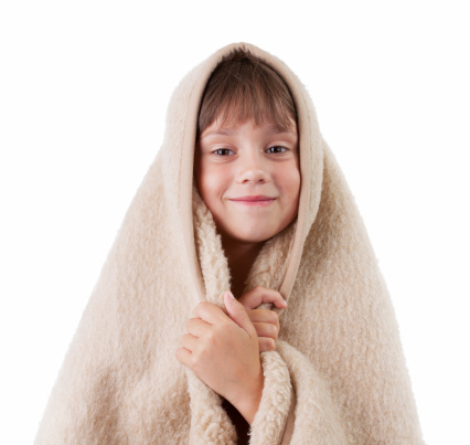 Little girl is basking under a woolen blanket