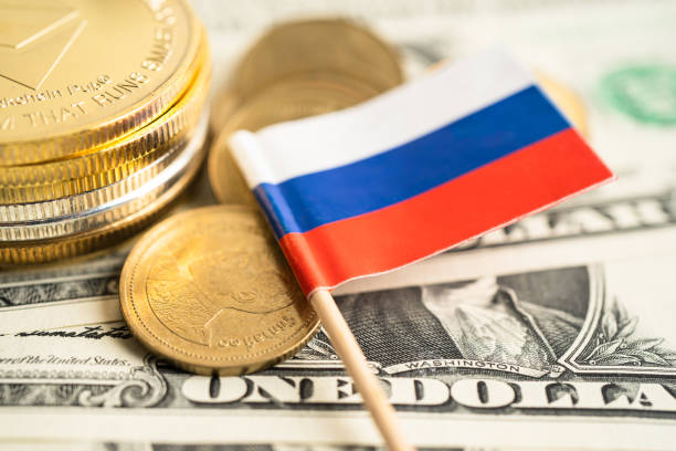 istock Stack of coins with Russia flag and US dollar banknotes. 1589930201