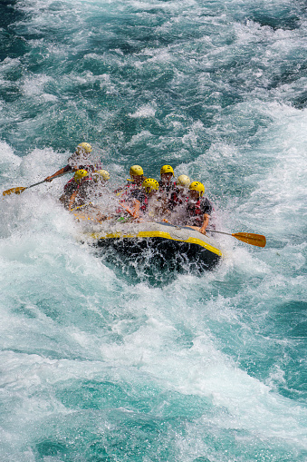 Group of people as they ride the rapids while white water rafting in the waves of a river. Koprulu Canyon Antalya, Turkey