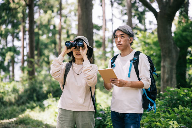 istock Japanese couple documents their birdwatching journey in a shared notebook amidst the tranquility of a forest. 1589945796