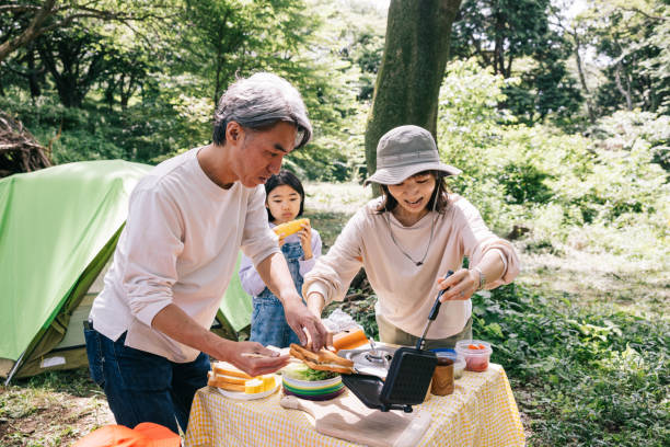 Japanese family cooking outdoors while camping