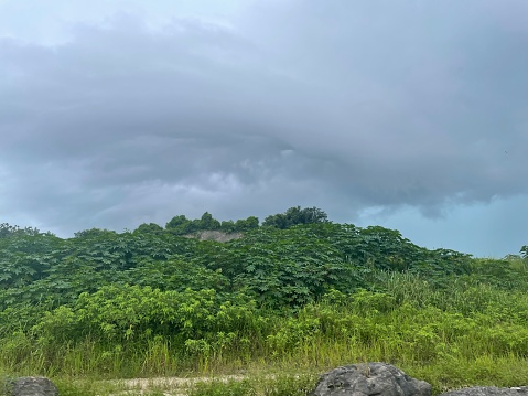 Dark cloud above mountain with greenery