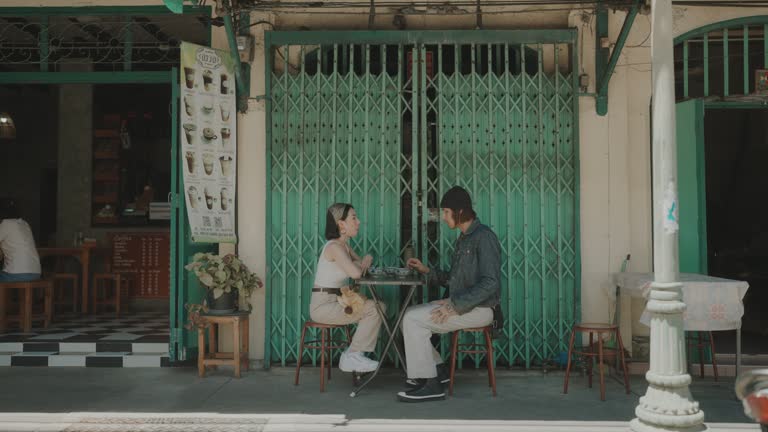 Young Couple Indulging in Sweet Thai Delights at Bangkok's Charming Street Food Scene.