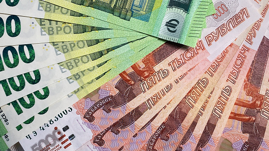 Currency exchange. Cash bills. Economics and finance. Several banknotes of 100 euros and 5000 rubles. The Russian national currency. Background of money.
