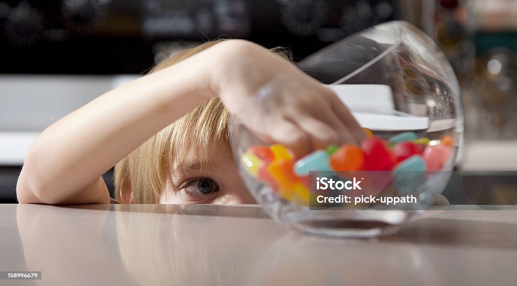 Boy And Candy Little boy looks at a candy jar. Child Stock Photo