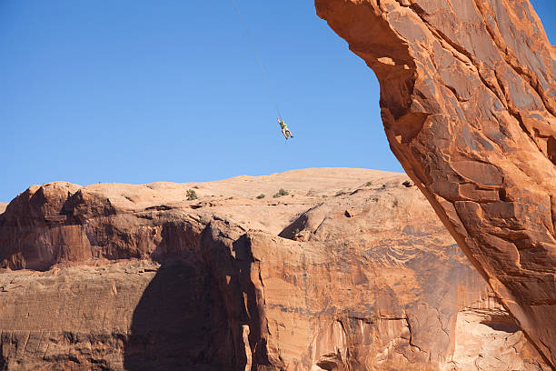 istock Man swings from corona arch moab 158997384