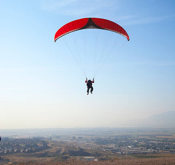 istock Man parasailing above small city 158997393