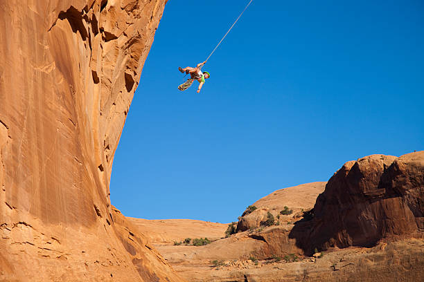 istock Man swings from corona arch moab 158997441