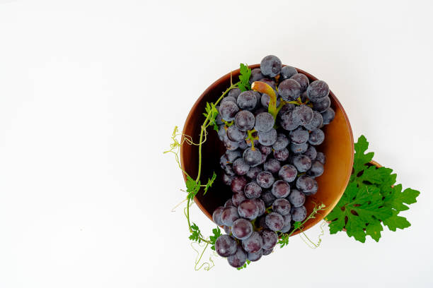 istock Purple grape Kyoho Grape with leaves on white background 1589975987