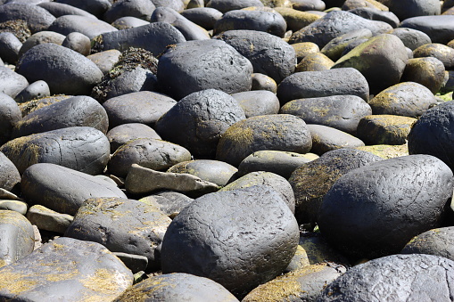 Round, smooth grey boulders on a beach