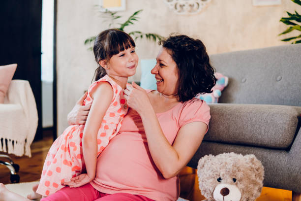 istock A pregnant mother hugs her small daughter 1590006177