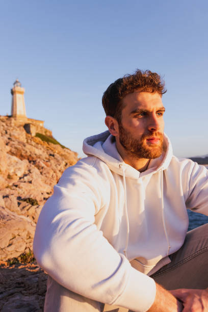 portrait of man sitting with a lighthouse