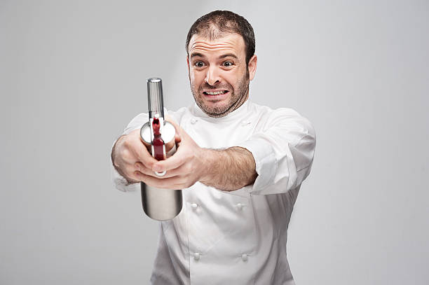 Mad Chef Holding Cream Whipper in a Grey Background