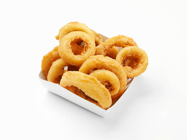 Six onion rings stacked in white background. The Background is slightly reflective and also the rings' shadow is cast on it