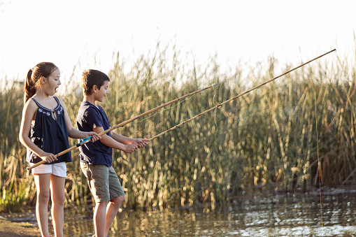 boy with his grandfather fishing on lake