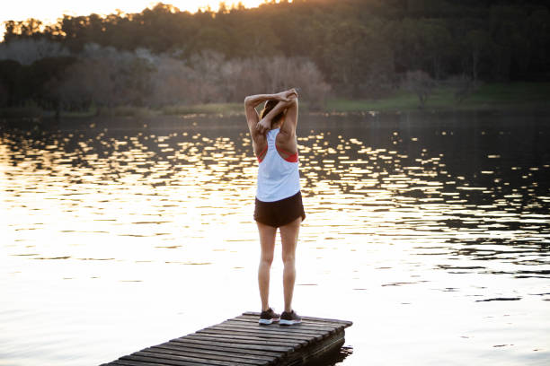 istock Woman exercising and stretching on lake dock 1590102608