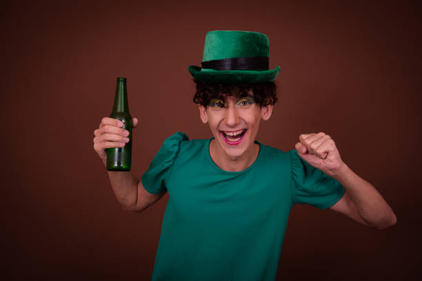 istock Drag Queen on St. Patrick's Day in a green hat drinks green beer. 1590123263