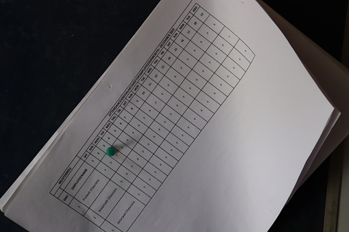 several papers of attendance sheet pinned with thumb pins on board