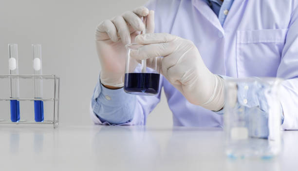 istock Science innovative Male medical or scientific laboratory researcher performs tests with blue liquid in laboratory. equipment science experiments technology Coronavirus Covid-19 vaccine research 1590138015