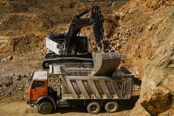 istock Hydraulic crawler excavator loading stone into truck in quarry at work 1590138747