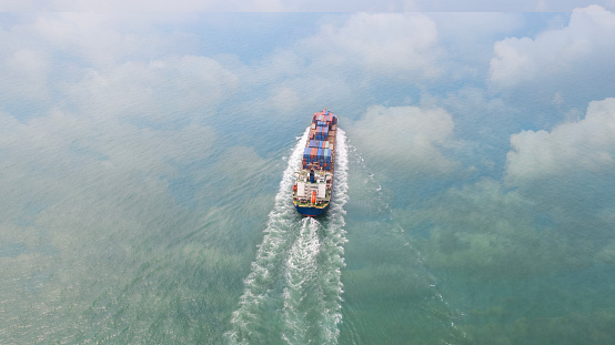 Aerial view of a ship out at sea on its way to making a large delivery. container ship in the ocean. Big cargo container ship fully loaded on its way across the sea. Sea transportation vessel.