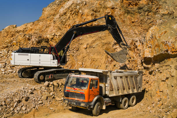 istock Hydraulic crawler excavator loading stone into truck in quarry at work 1590153359