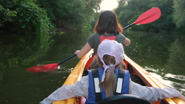 Mother and little daughter enjoy kayaking adventure on the river