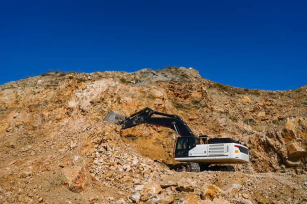 Hydraulic crawler excavator extracting stone in quarry at work