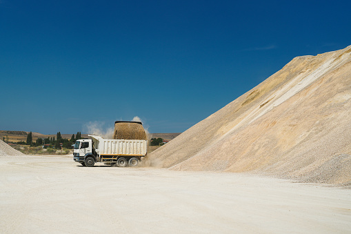 Excavator loading sand into truck in a sand quarry