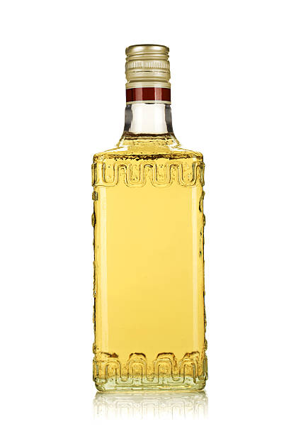 Generic bottle of gold tequila on a white surface Bottle of gold tequila. Isolated on white background tequila drink photos stock pictures, royalty-free photos & images