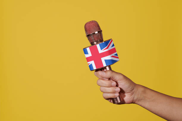 istock man has a microphone patterned with the flag of UK 1590189566