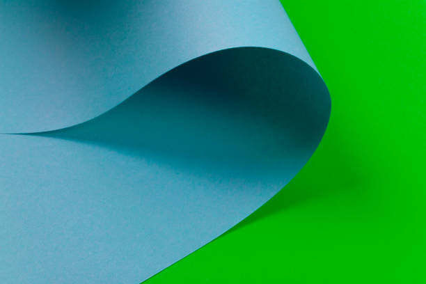 abstract design of blue curve shaped paper on green background. copy space. flat lay. - 3504 imagens e fotografias de stock