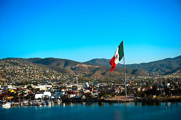 Port of Ensenada and Mexican flag A large Mexican flag flying at the Port of Ensenada. baja california peninsula stock pictures, royalty-free photos & images
